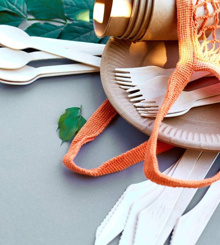 Flat lay of eco craft paper and wooden tableware, Zero waste, plastic-free and eco-friendly living, paper cups, dishes, bag, plates and wooden cutlery in cotton mesh bag, recycling or eco-friendly concept.
